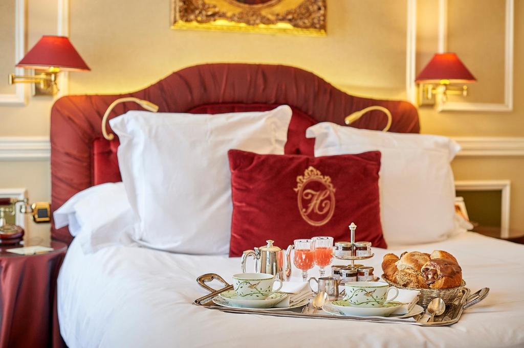 布鲁日历史休闲和城堡酒店的床上装有食物和饮料的托盘