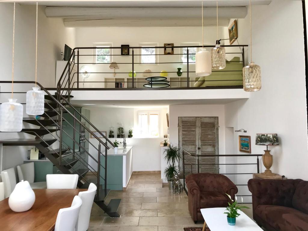 穆斯捷-圣玛丽La Maison du Courtil, Amande-Olive的客厅设有螺旋楼梯和桌子