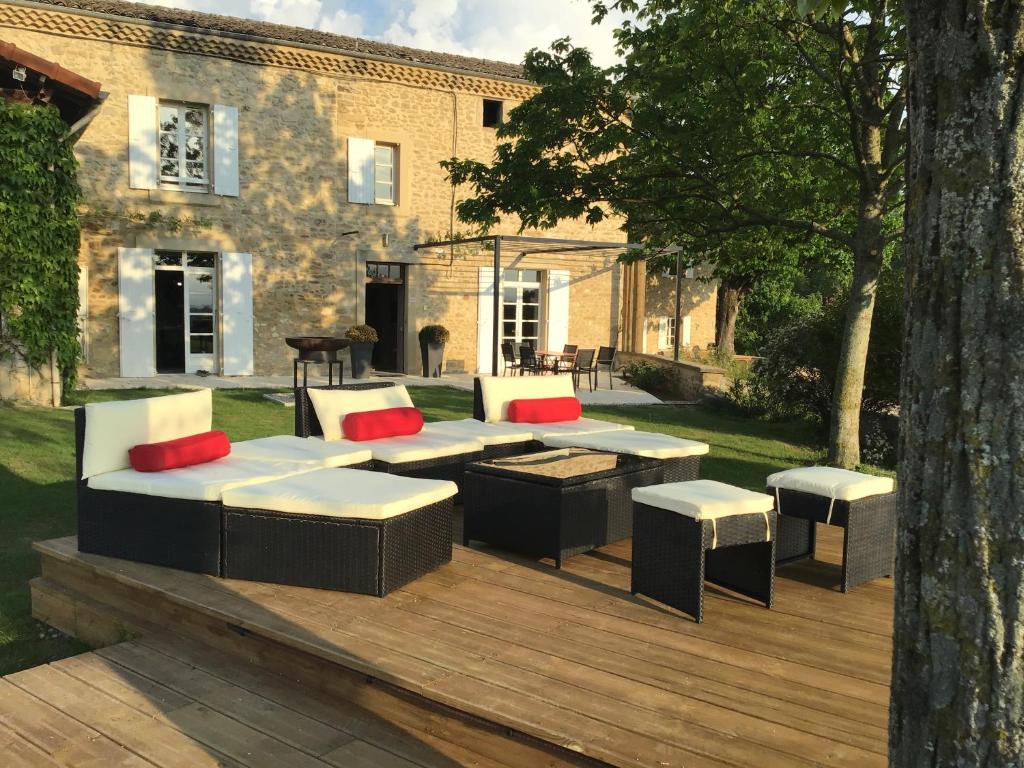 BarcelonneAgréable bastide provençale avec piscine的木制甲板上配有沙发和桌子的庭院