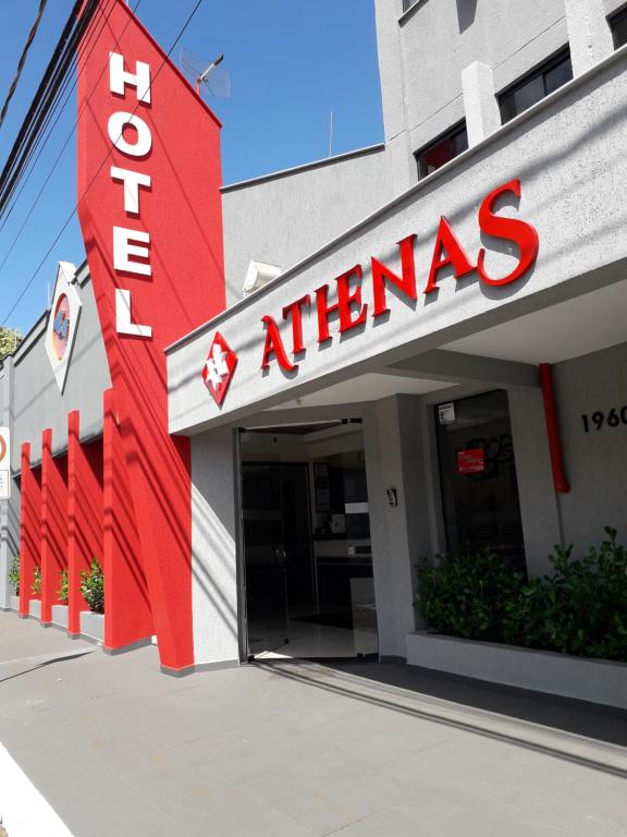 阿拉萨图巴Hotel Athenas e Convenções的前面有红色标志的建筑