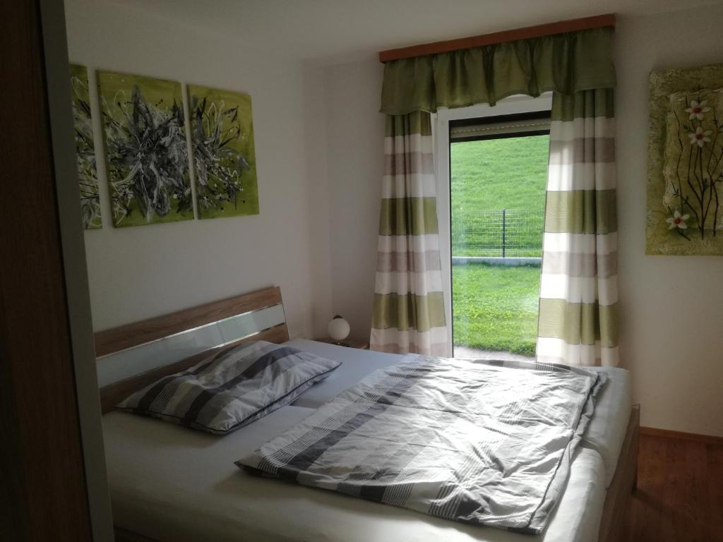 Oberhofen am Irrsee米特鲍尔度假屋的一间卧室设有一张床和一个窗口