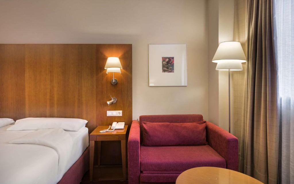 萨莫拉萨莫拉帕拉西奥德尔杜罗NH酒店的配有一张床和一把椅子的酒店客房
