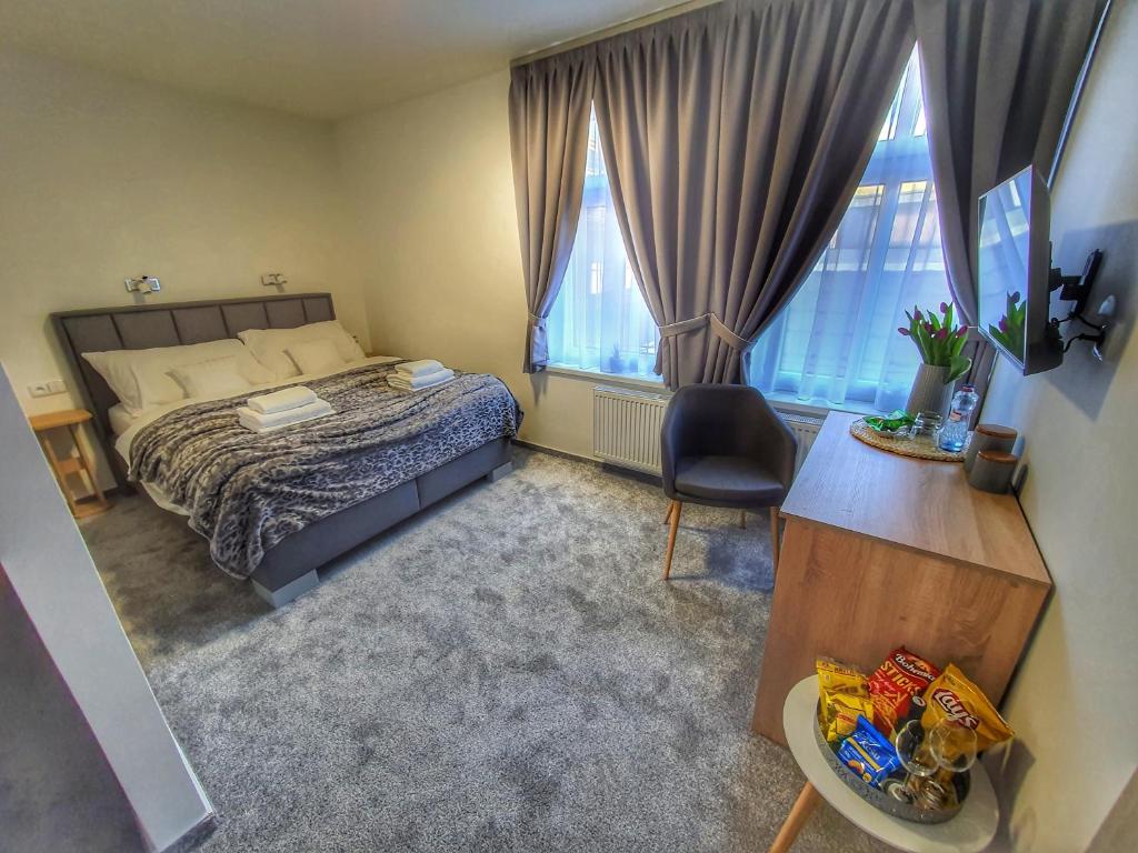 耶塞尼克Penzion Gemer的一间卧室配有一张床、一张书桌和两个窗户。