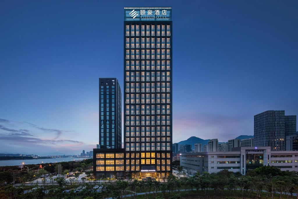 福州Yiho Hotel Mawei Fuzhou的一座高大的建筑,城市里灯火通明