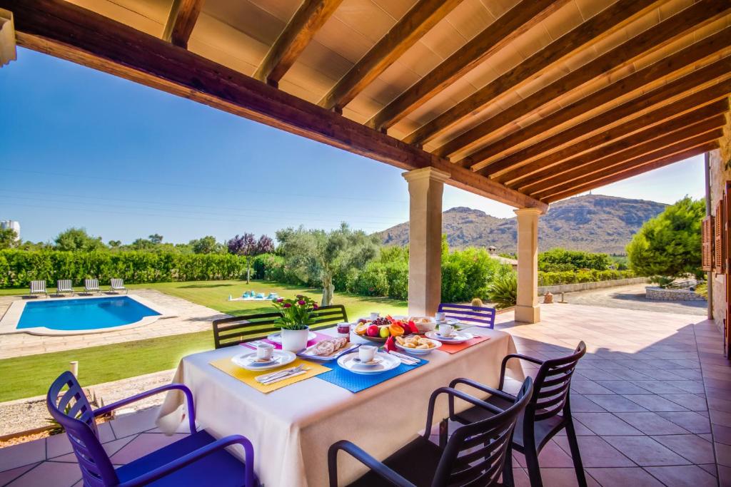 阿尔库迪亚Ideal Property Mallorca - Ses Poves的享有泳池景致的庭院内的餐桌