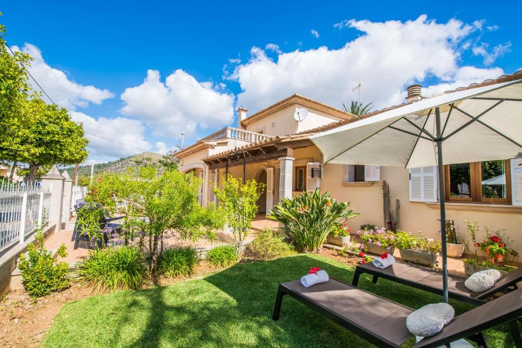 阿尔库迪亚港Ideal Property Mallorca - Villa Celia的庭院里设有遮阳伞和椅子