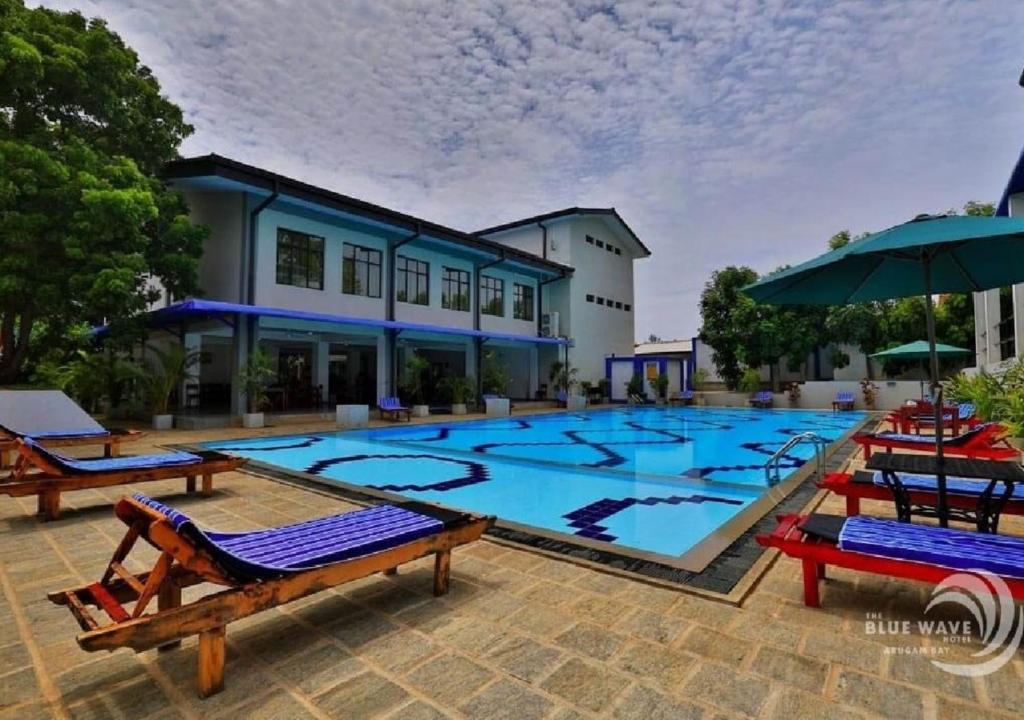 阿鲁甘湾The Blue Wave Hotel的一个带椅子和遮阳伞的大型游泳池