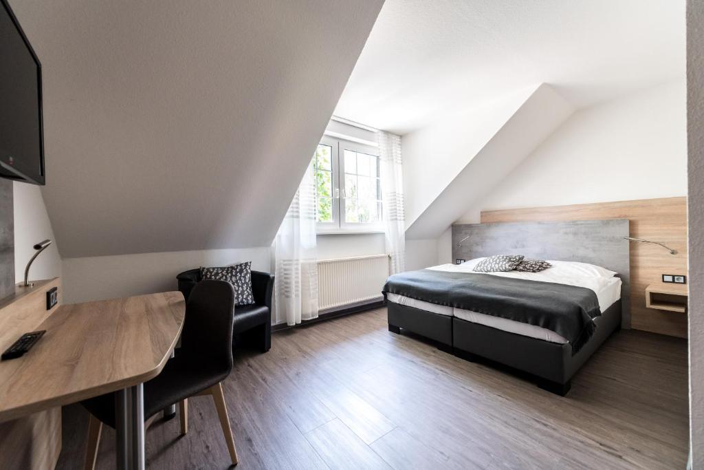 明斯特Hotel Hüerländer的一间卧室配有一张床、一张桌子和一张桌子