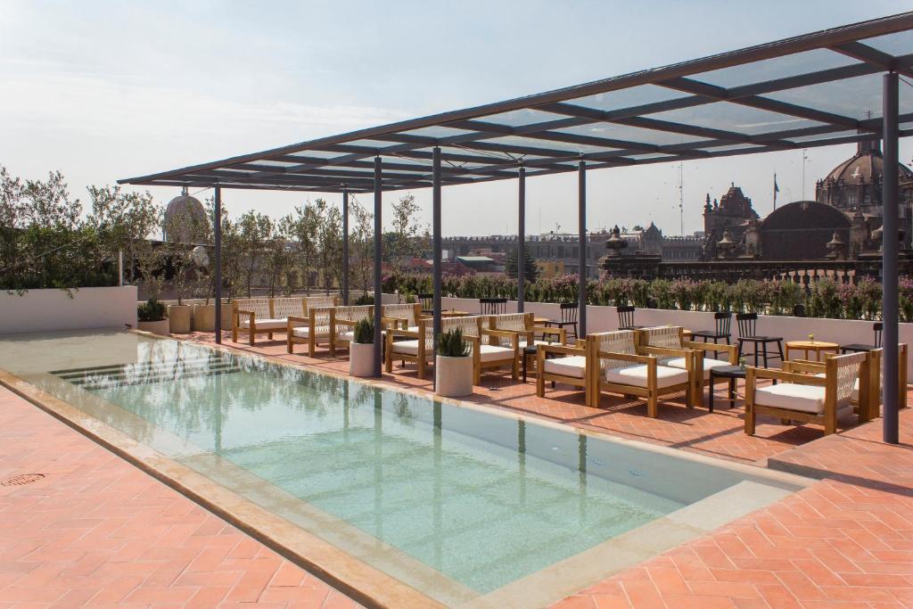 墨西哥城Círculo Mexicano, a Member of Design Hotels的一个带桌椅的游泳池和一个凉亭