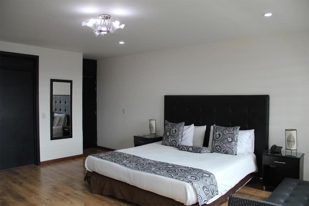 波哥大圣达菲瑞酒店的一间卧室配有一张大床和黑色床头板