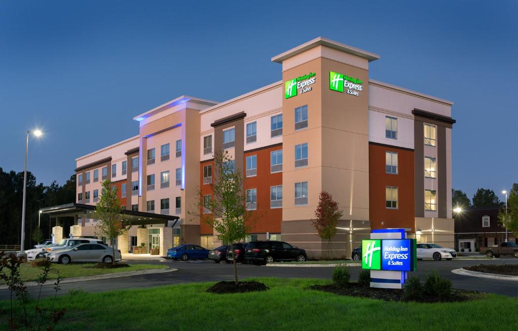 费耶特维尔Holiday Inn Express & Suites - Fayetteville South, an IHG Hotel的酒店大楼前面设有停车场