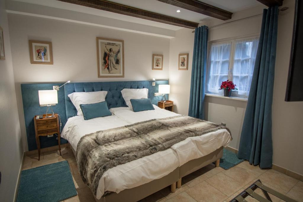 斯特拉斯堡Gite **** des Bains的一间卧室配有一张带蓝色窗帘的大床
