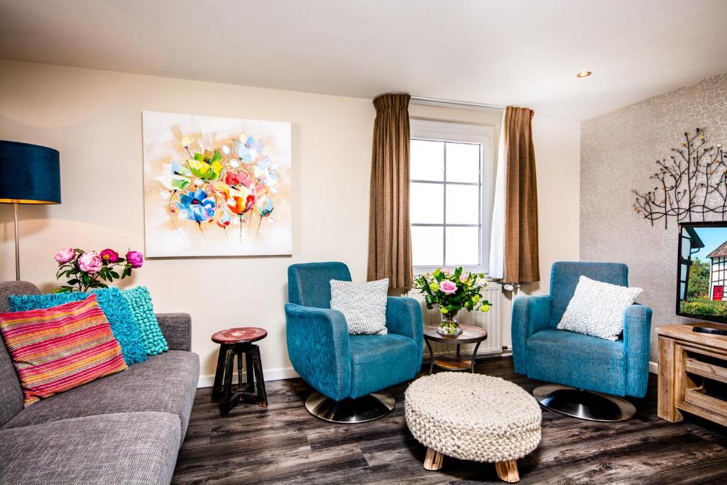 埃彭Aparthotel Ons Epen的客厅配有2把蓝色椅子和电视