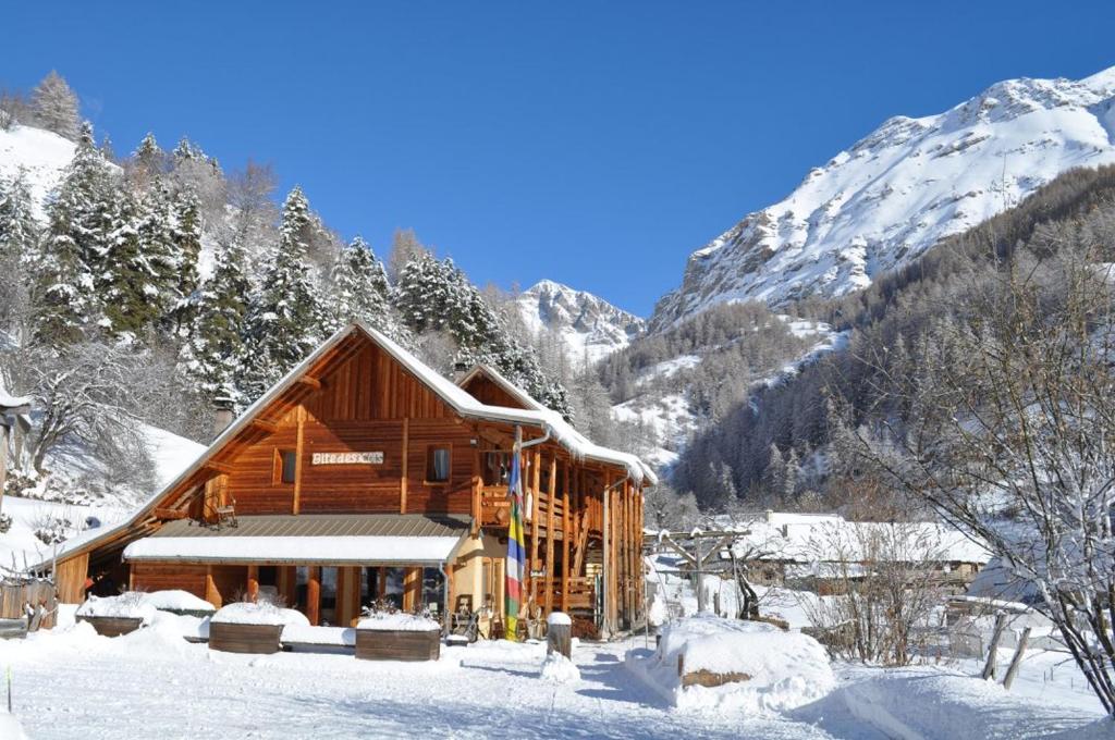 雷阿隆Gîte les 3 cols的雪中小木屋,背景是群山