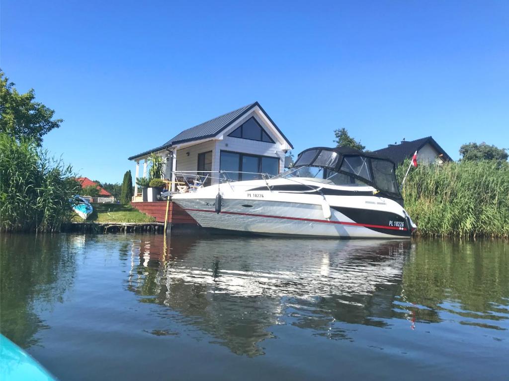 斯维诺乌伊希切Baltic Waterfront Yacht House的停泊在水面上的房子前面的船只