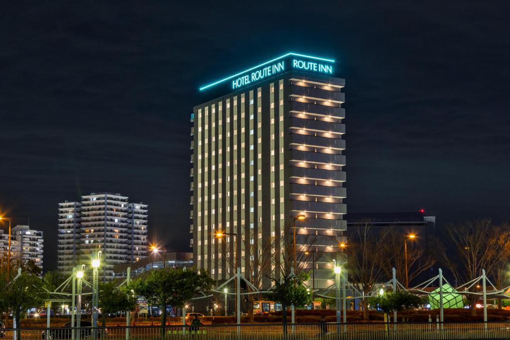 印西Hotel Route Inn Chiba Newtown Chuo Ekimae - Narita Airport Access Line的一座高大的建筑,晚上有标志