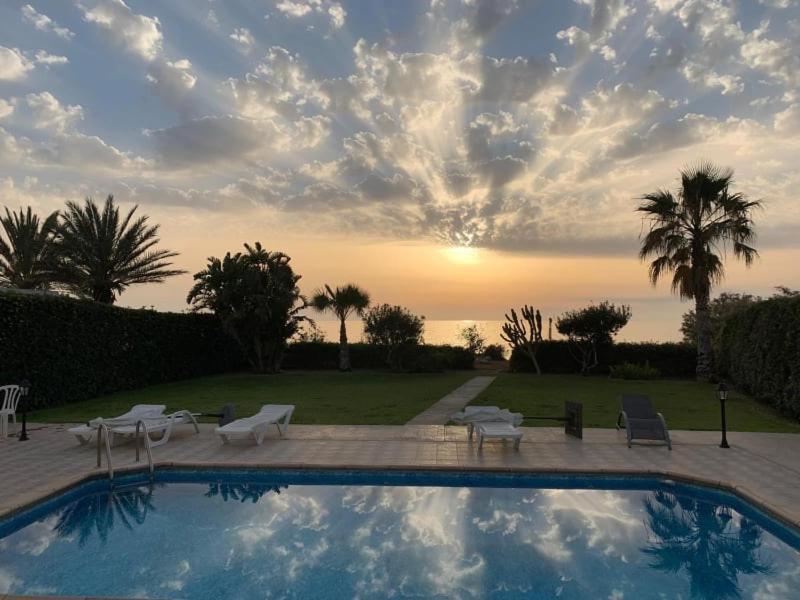 Ayia MarinaOlgas Villa的一个带椅子的游泳池,享有日落美景