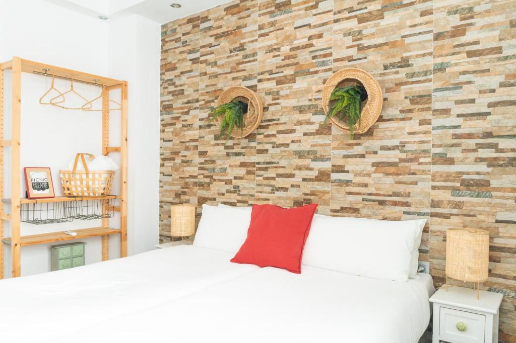马拉加野餐梦幻精品旅馆的卧室配有白色的床和砖墙