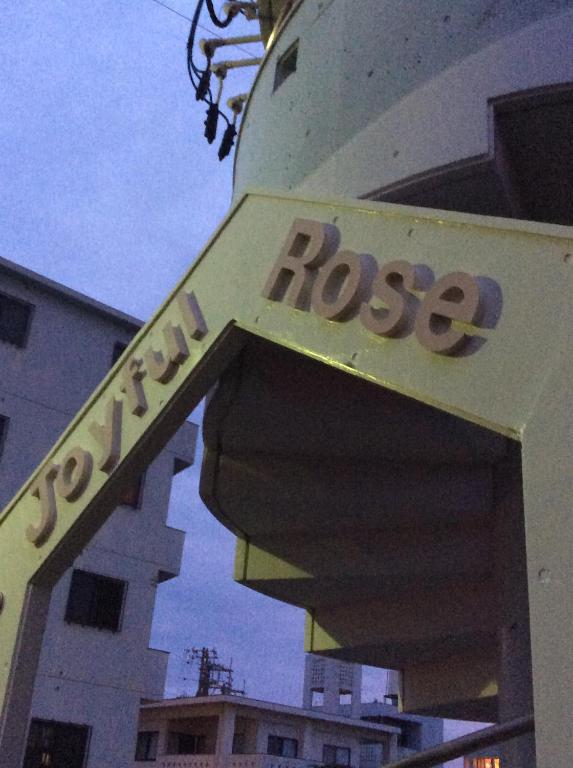 宜野湾市Joyful Rose的建筑物一侧的玫瑰花标志