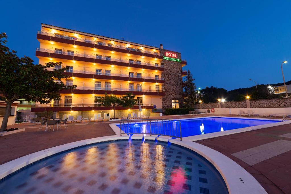 滨海托萨BLUESEA Continental的大楼前设有游泳池的酒店