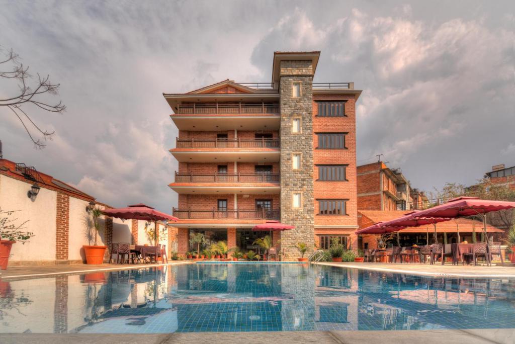巴克塔普尔Hotel Bhadgaon的大楼前设有游泳池的酒店