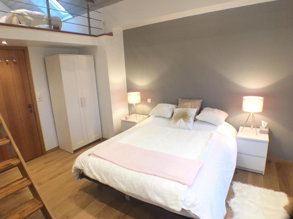 维尔雅尔姆B&B Pegasus II - Chambre de luxe avec sauna privatif的一间卧室配有一张带两盏灯的大型白色床。
