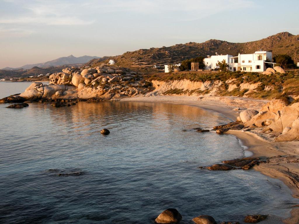 米科利维亚Studios Kontos的山丘上拥有岩石和房屋的海滩