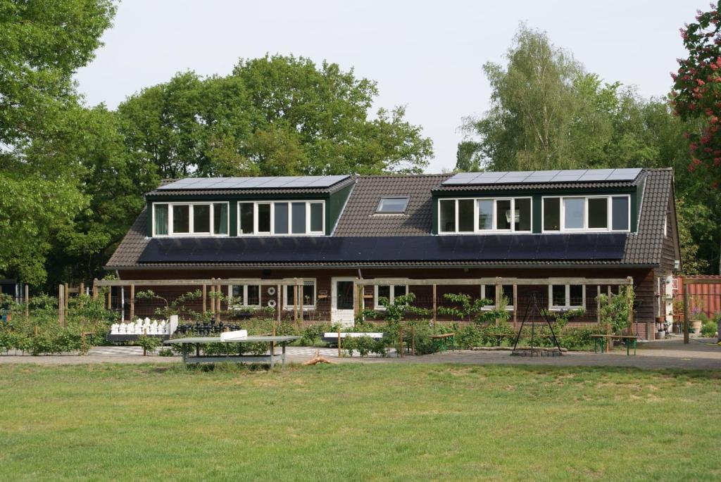 Heeswijk-DintherVakantieboerderij 't Zand - Appartement的一座带太阳能电池板的院子顶部房子