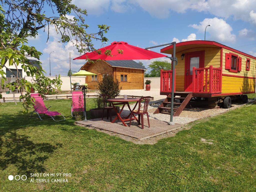 库谢韦尔尼domaine des chevrettes的一个小房子,配有桌子和红伞