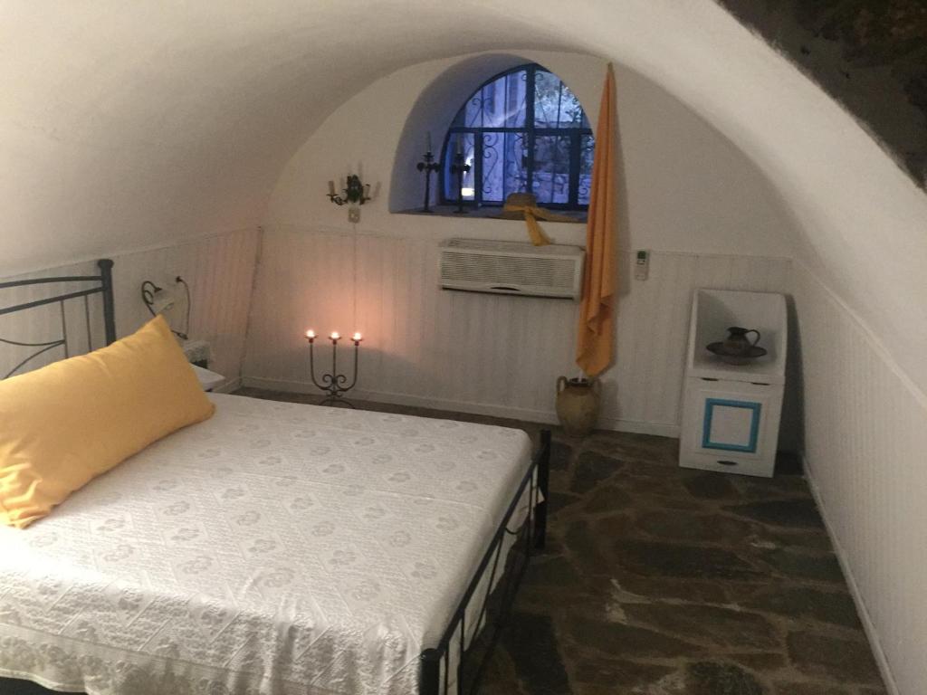 TrakhílaLagadi 1860的一间卧室设有一张床和一个窗口