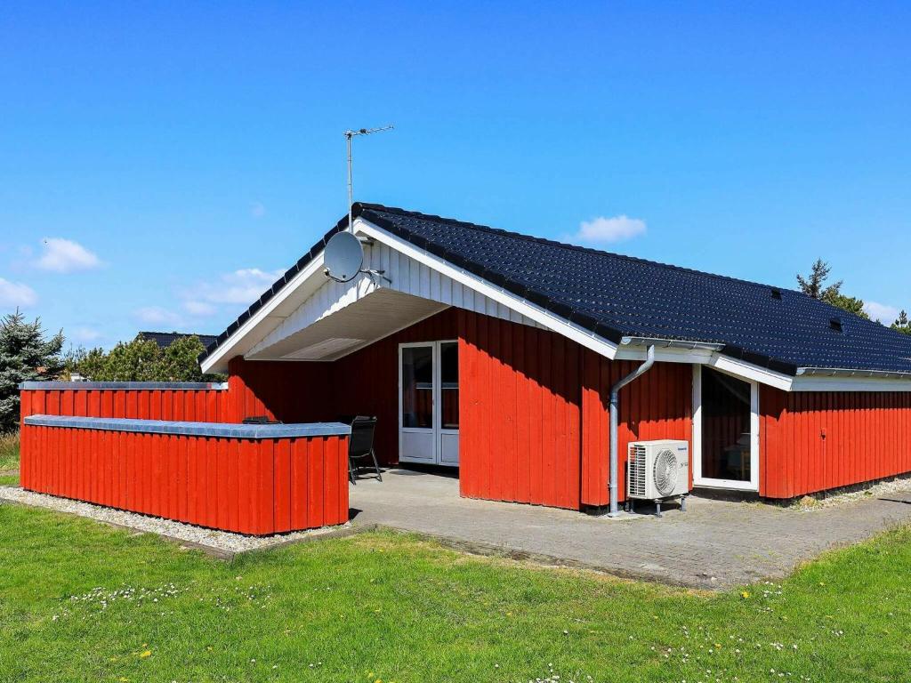瓦伊厄斯斯特兰德8 person holiday home in Vejers Strand的前面有栅栏的红色房子