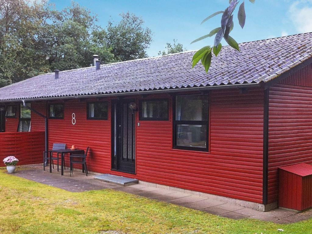 锡尔克堡5 person holiday home in Silkeborg的院子里的红色房子,有桌子