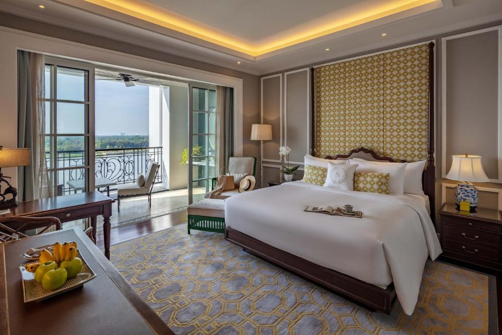 胡志明市Mia Saigon – Luxury Boutique Hotel的一间带大床的卧室和一个阳台