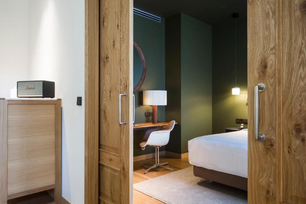 圣塞瓦斯蒂安Hotel Arbaso的一间卧室配有一张床和一张桌子及椅子