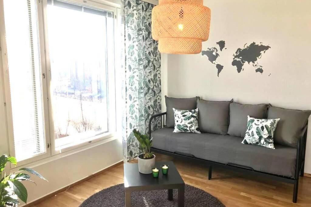 万塔Casa Verde nearby Helsinki airport的客厅配有沙发,墙上挂着世界地图