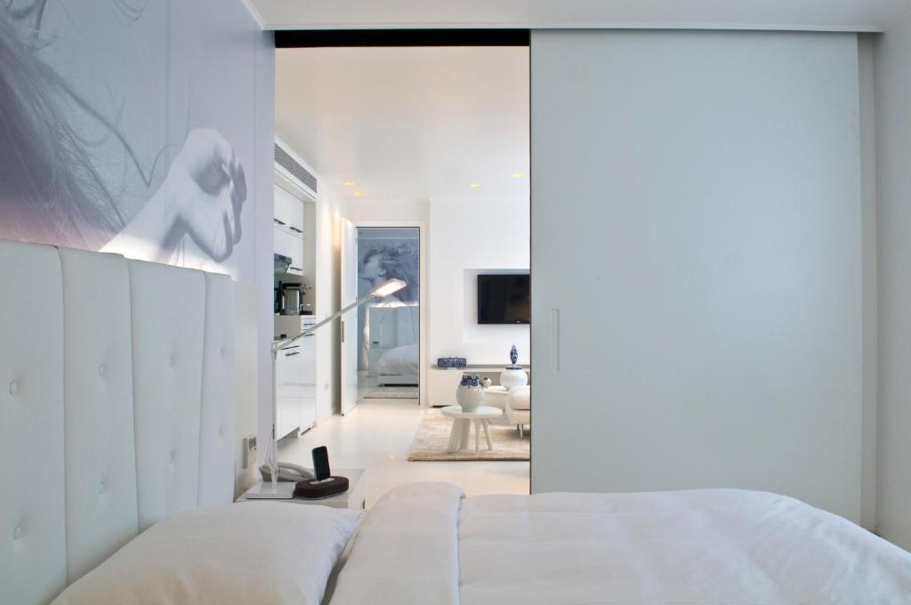 布鲁塞尔丽晶B公寓式酒店的一间带白色床的卧室和一间客厅