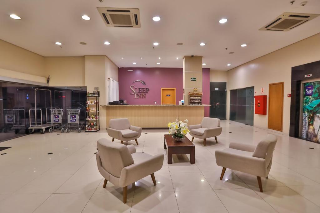 马瑙斯马瑙斯司丽普酒店的大堂设有配备椅子和鲜花的等候室