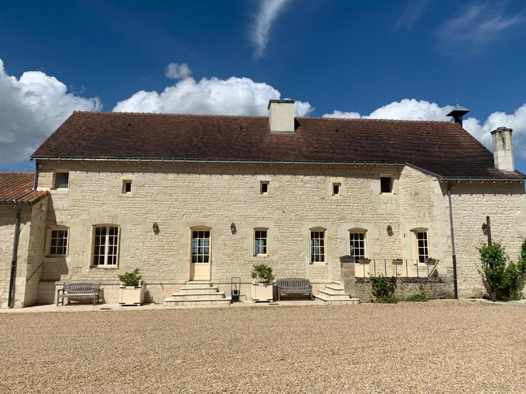 Marigny-BrizayFarmhouse in a working winery with vineyard views的棕色屋顶的白色砖砌大建筑