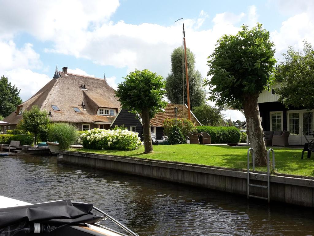 泰尔霍讷d'Oude Herbergh, vakantiehuizen aan het water的河边的房屋,有船