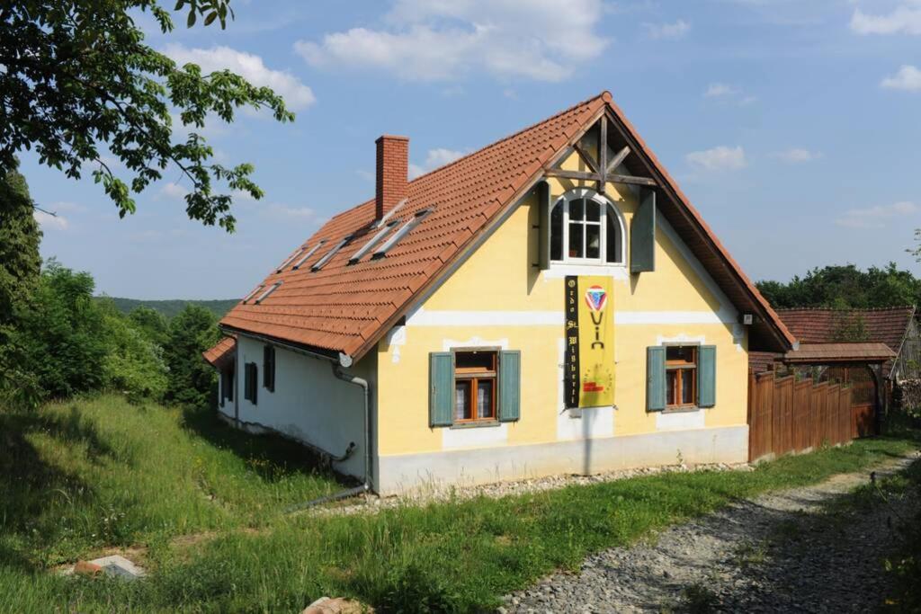 FelsőszölnökStilvolles Landhaus im Dreiländereck的红色屋顶的黄色小房子