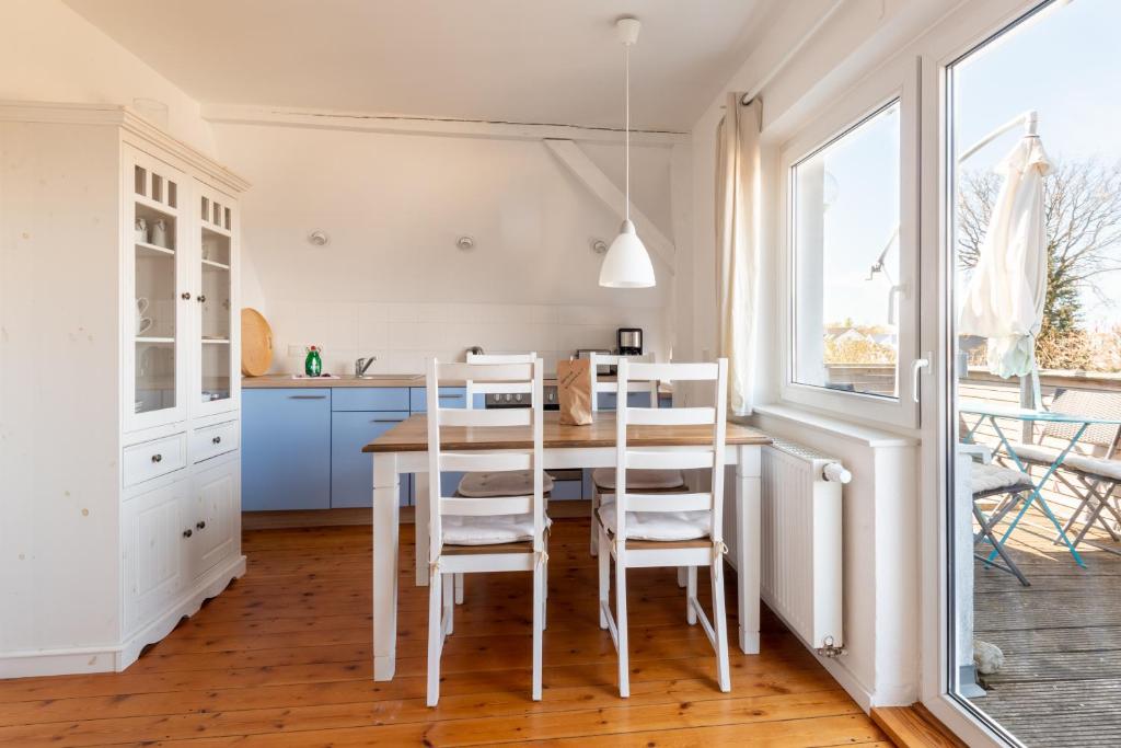 格拉尔-米里茨Ferienwohnung BROMBEERE mit großem Garten und Balkon的厨房配有桌椅和窗户。