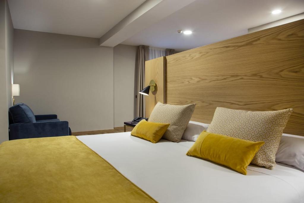 托莱多曾特拉尔马约拉尔酒店的一间卧室配有一张带黄色枕头的大床