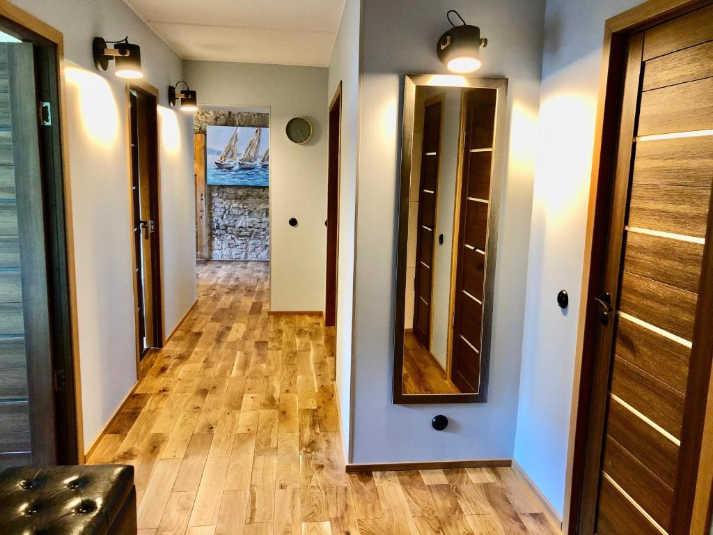 库雷萨雷Kohtu Apartment Epoch的走廊设有木地板和镜子