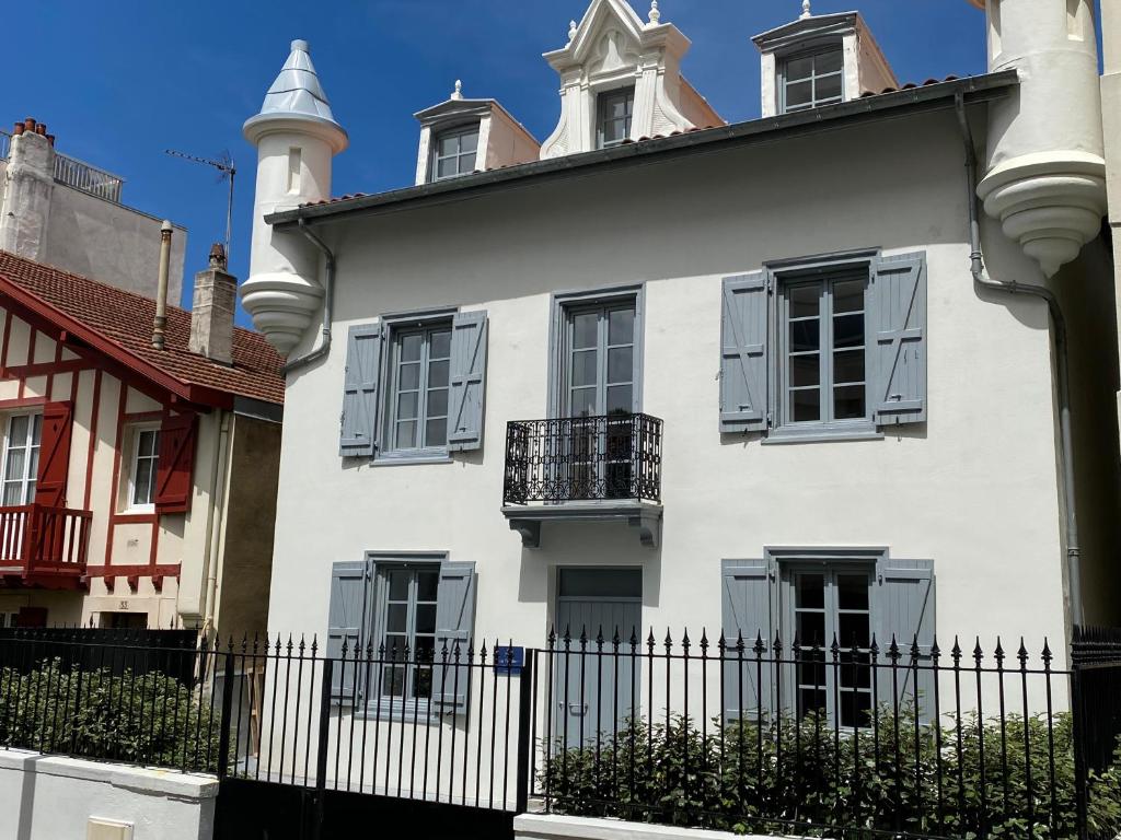 比亚里茨Les Tourelles的前面有栅栏的白色房子