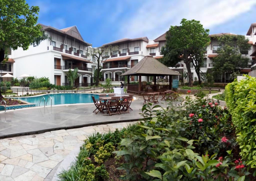 罗纳瓦拉Rhythm Lonavala - An All Suite Resort的一个带游泳池和桌椅的度假酒店