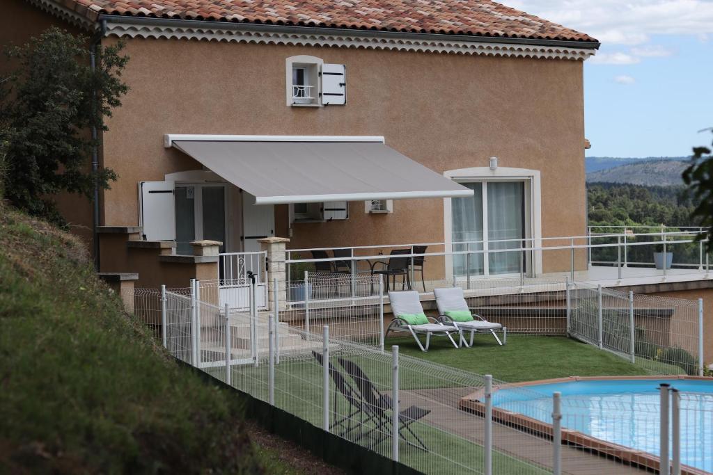 瓦尔莱班Les Clos De La Vigne的一座带游泳池和白色遮阳伞的房子