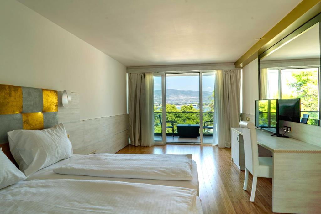 特罗吉尔斯维提克里兹酒店的一间卧室配有一张床和一张书桌及电视