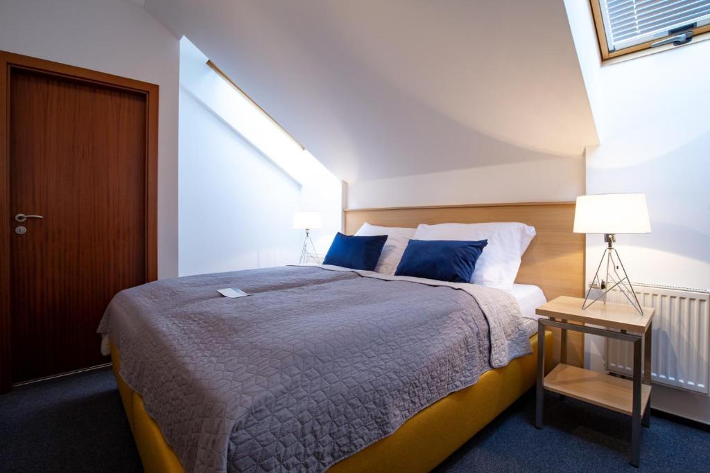 HoromysliceGreensgate Hotel Dýšina的一间卧室配有一张带蓝色枕头的大床