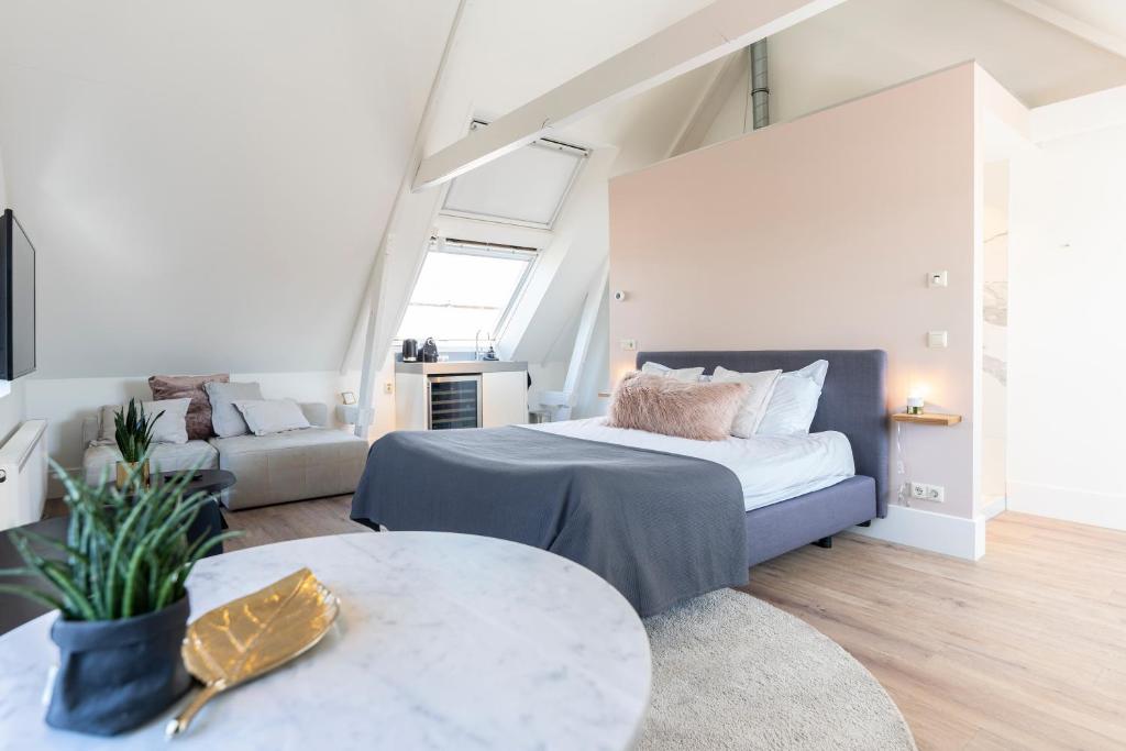 登堡Gravenstraat的一间卧室配有一张床、一张沙发和一张桌子