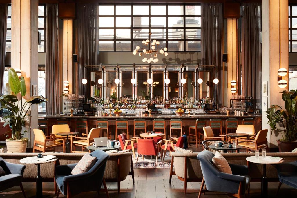 芝加哥The Hoxton, Chicago的餐厅设有酒吧,配有桌椅